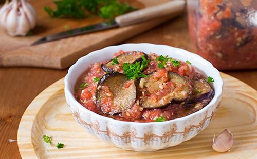 На масата е чиния с патладжан и домати