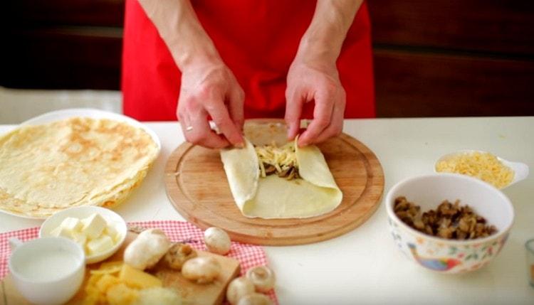 Увийте палачинки с гъби и сирене в пликове.