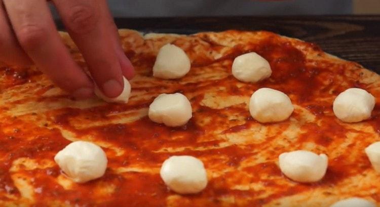 Равномерно разпределете парчетата моцарела.