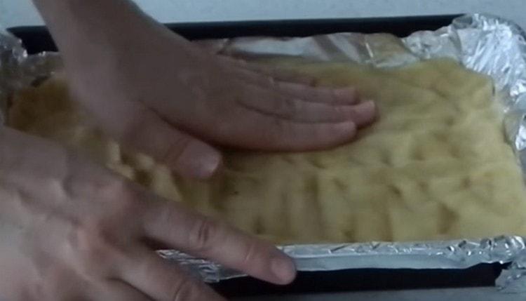 подредете листа за печене по-голямата част от тестото. правене на малки страни.