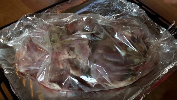 Разстелете маринованото месо в ръкав върху лист за печене и сложете във фурната.