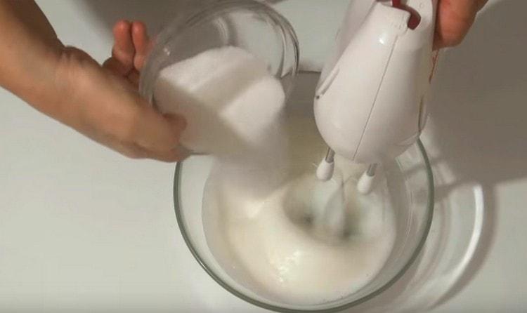 Разбивайки масата, въвеждаме захар в белтъците.