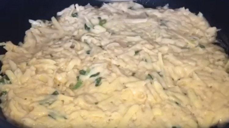 Загряваме тигана и разпределяме картофената маса върху него на равен слой.
