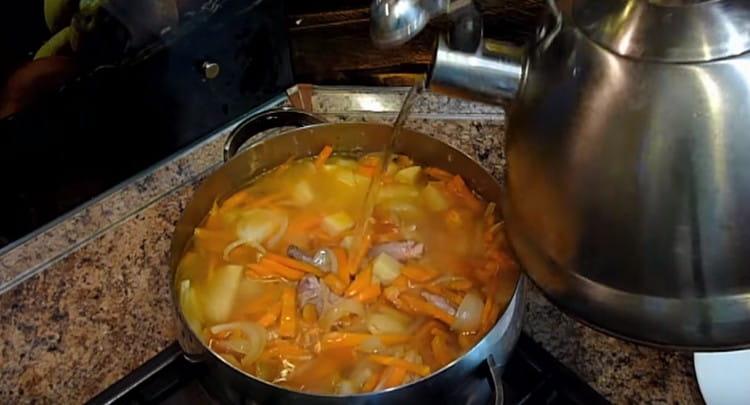 Също така слагаме задушените зеленчуци в тигана и добавяме вода.