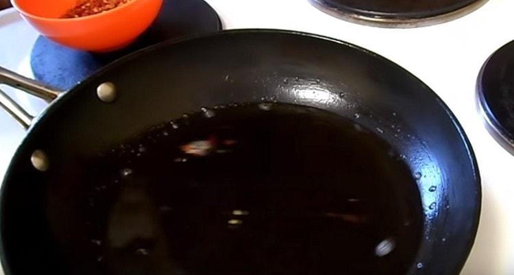 Загрейте растителното масло в тиган.