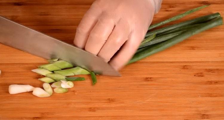 Нарежете зеления лук наклонено.