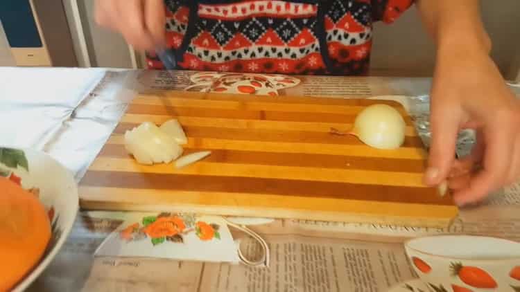 За да готвите задушен заек със зеленчуци, накълцайте лука