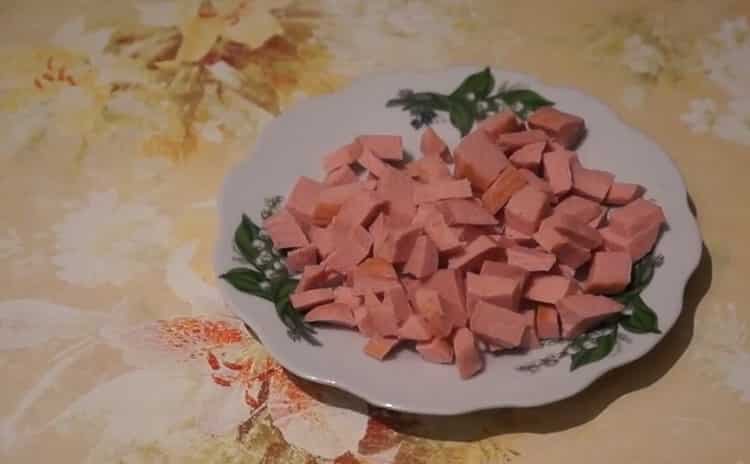За да направите пица с наденица и сирене, нарежете наденицата
