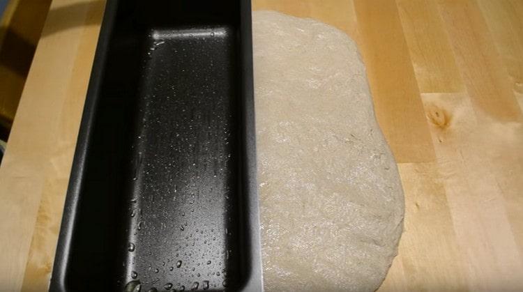 След това прехвърляме тестото на маса, намазана с растително масло, печенето също трябва да се намаже.
