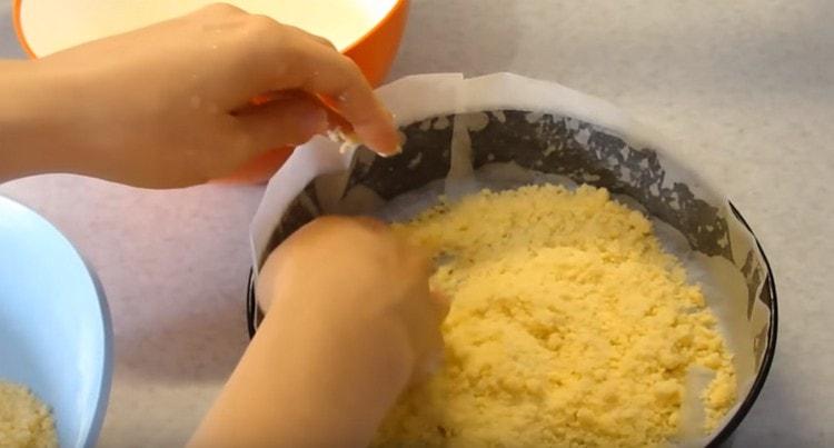 Разпределете третата част от тестото за трохи на дъното на формата.