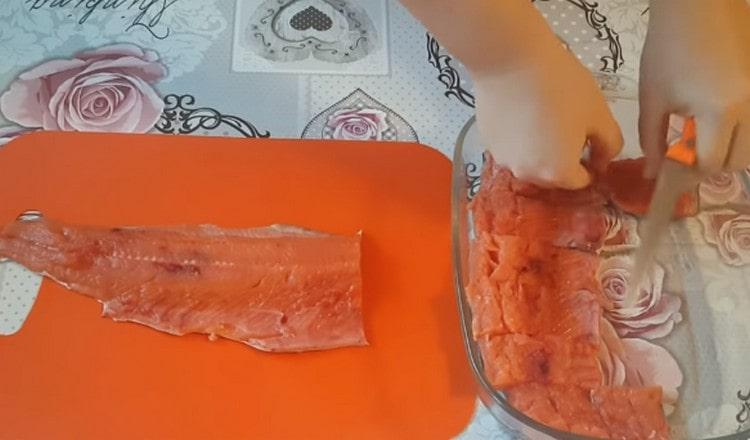 Нарежете филето на парчета и го сложете на един слой в намазнена форма с растително масло.