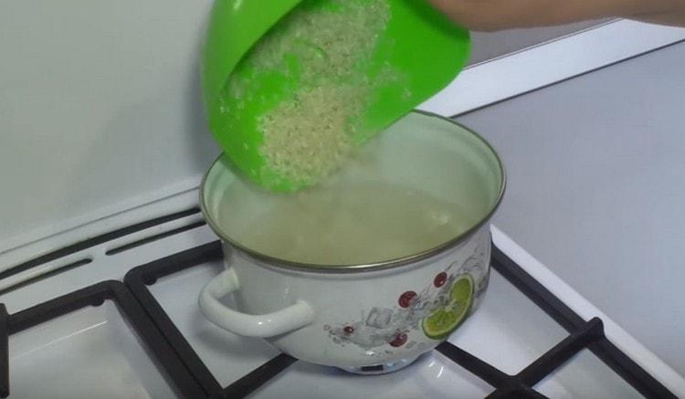 Разпределяме ориза във вряща вода и готвим до омекване.