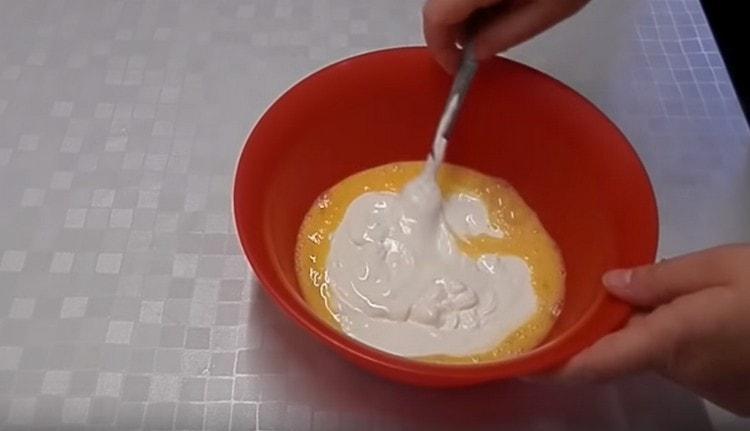 Добавете заквасена сметана към яйчената маса.