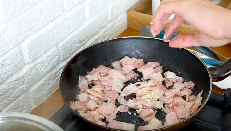 Добавете чесъна към бекона.