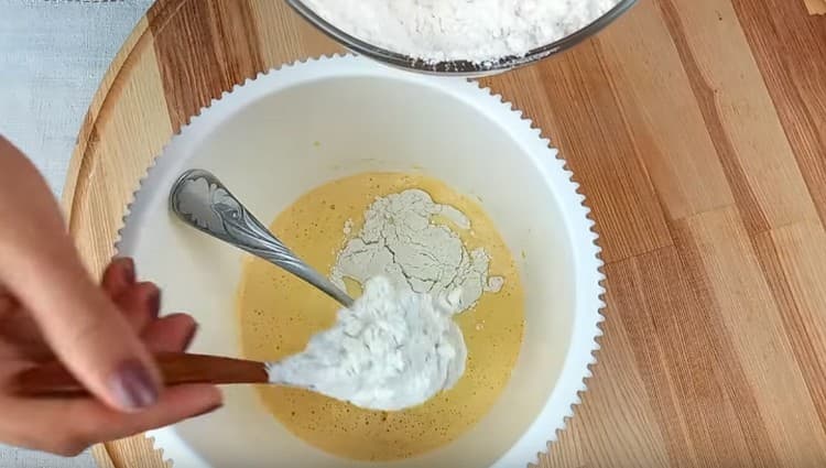 Добавете брашното и продължете да омесвате тестото.