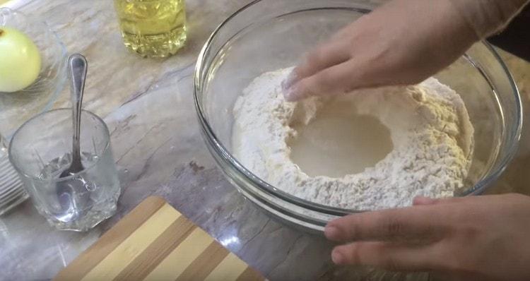 Налейте вода в канала в брашното, но не всичко наведнъж.