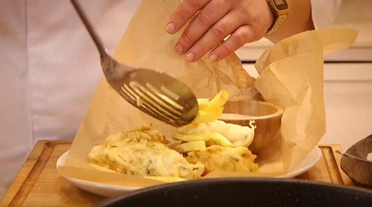 Сервирайте филе от треска в тесто с пържени картофи и сос.