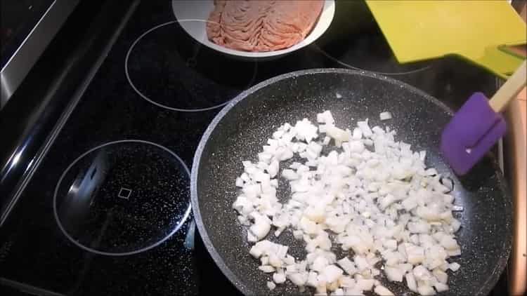 За да направите месни банички във фурната, пасирайте лука