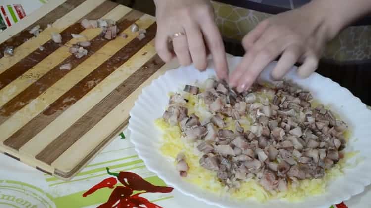 За да готвите херинга под кожено палто, нарежете рибата
