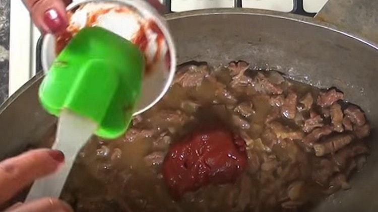 Към месото с лука добавете лъжица брашно и доматеното пюре.