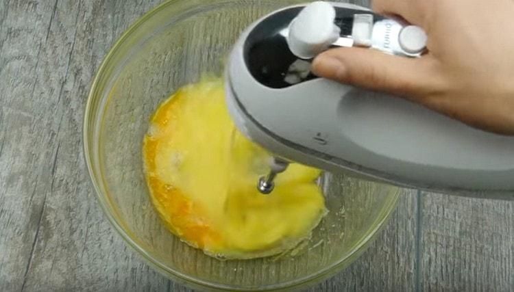 Разбийте яйцата със захарта отделно.