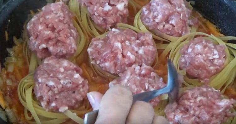 Пълним гнездовата паста с кайма и я слагаме в тиган за зеленчуци.