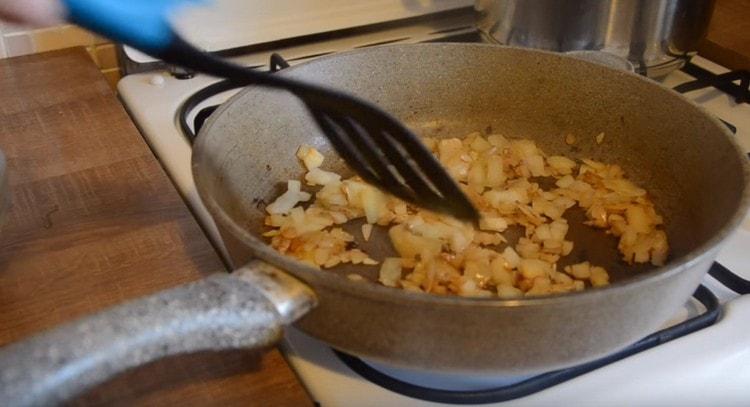 Запържете лука в маслото до златисто кафяво.
