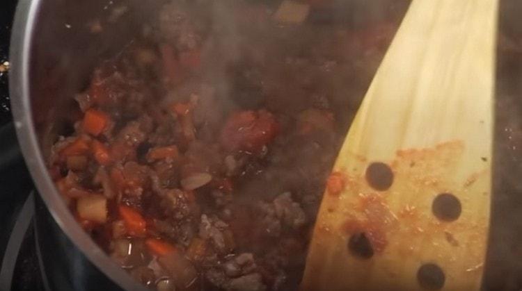 Добавяме и вода и оставяме соса болонезе да се задушава.