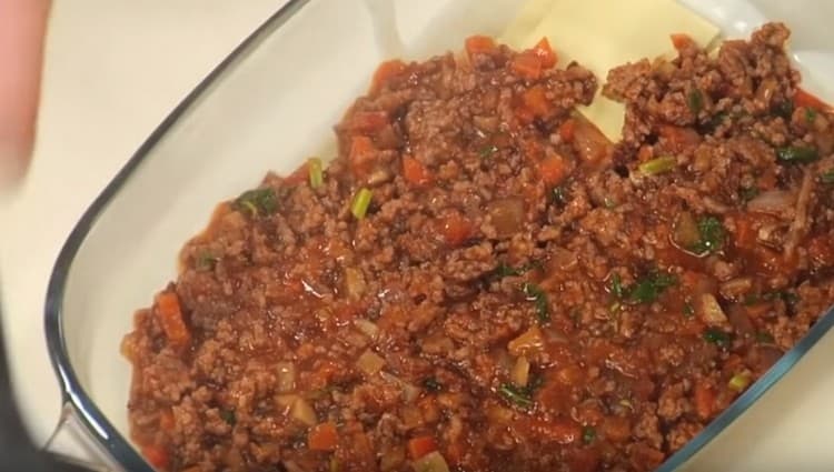 Покриваме чаршафите лазаня със сос болонезе.