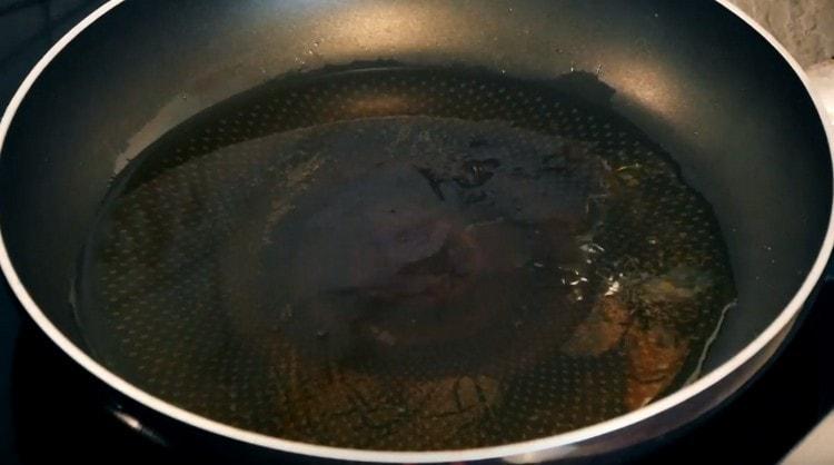 Загрейте тигана със зехтин.