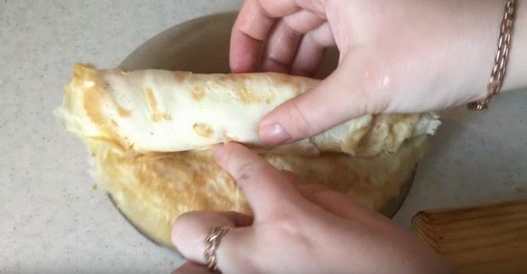 Сгънете готовите палачинки една върху друга и усучете рулото.
