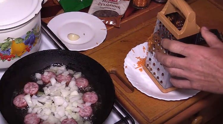 Добавете лука към колбаса в тигана.