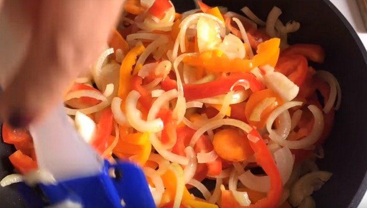 също нарязваме лука, сладките чушки, добавяме към морковите в тиган.