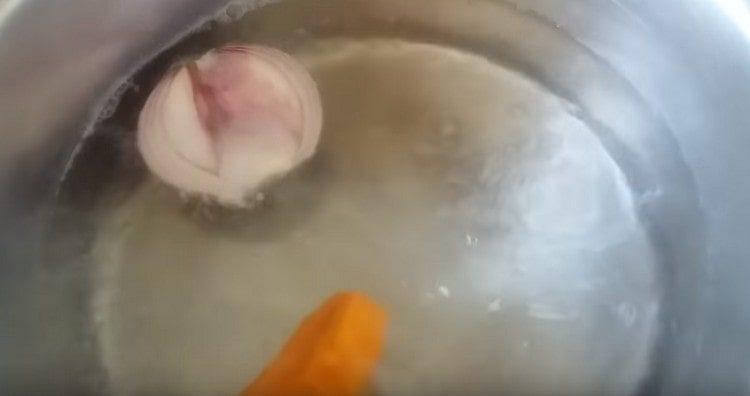 Доведете водата до кипене в тиган, добавете лука и морковите, солта.