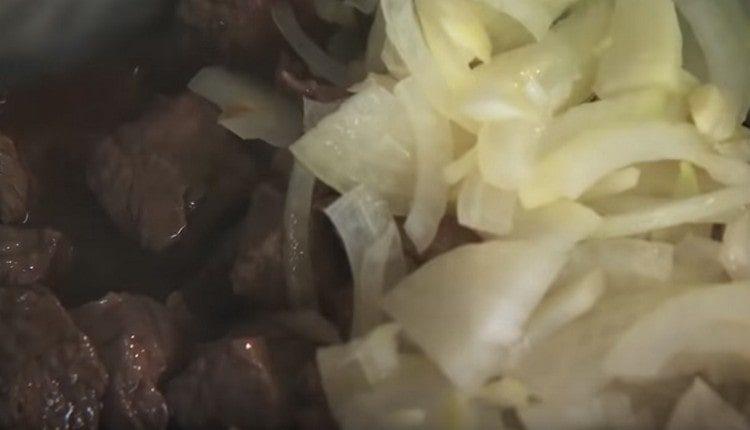 Добавете лука с чесъна към месото.