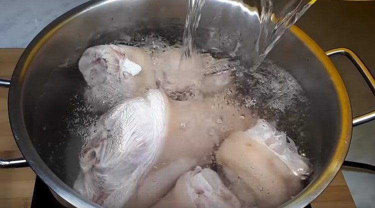Изсипете свинските бутчета с вода и доведете до кипене.