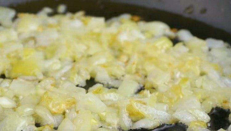 Запържете нарязан лук в тиган.