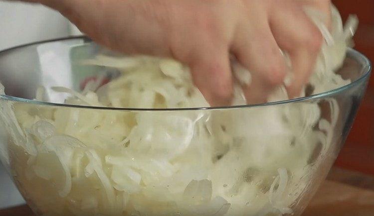 нарязваме лука на пръстени и омесваме със сол.