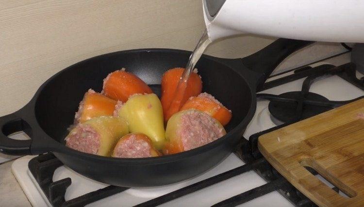 Сложете чушките в тиган или тиган и напълнете с вода.