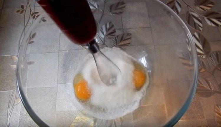 Разбийте яйцата със захарта.