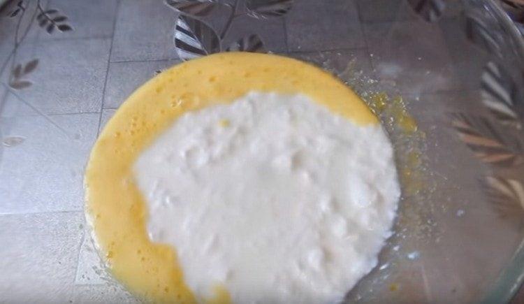 Към яйчената маса добавете сол и кисело мляко.