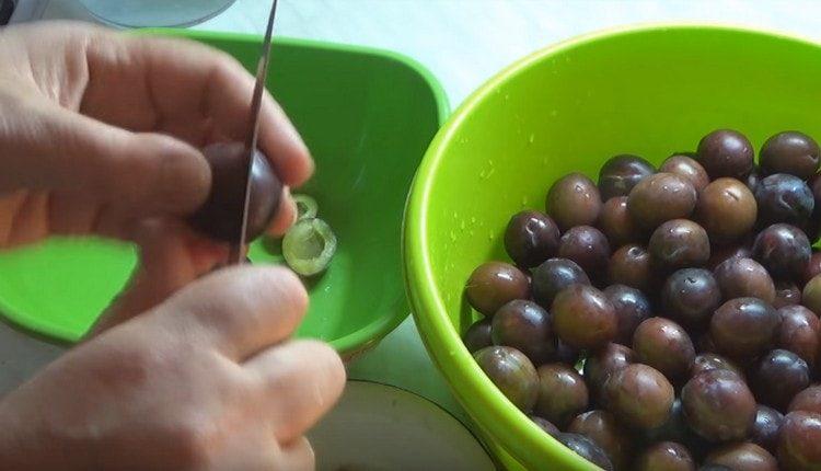 Нарежете измитите сливи наполовина и отстранете семената.