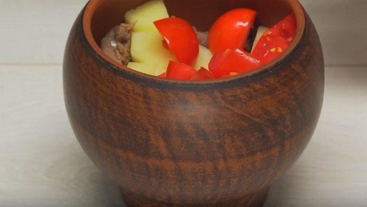 В долната част на съда за печене сложете соса, нарязания килантро, месо, картофи и домати.