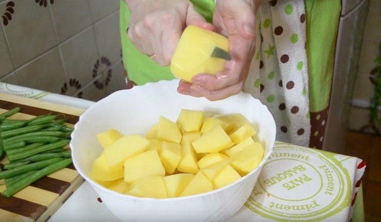 Обелете и нарежете картофите доста големи.