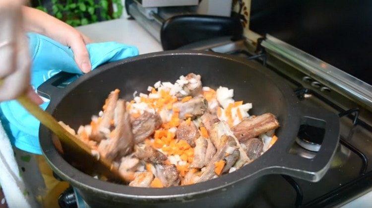 Добавете моркови с лук в казана към ребрата.