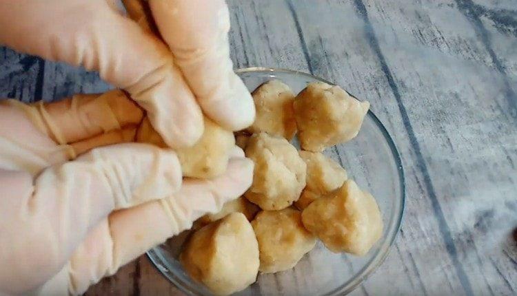 Разделете кокосовата маса на топки.