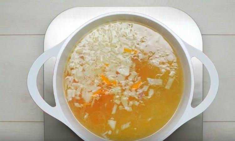 В бульона разпределяме лук с моркови.